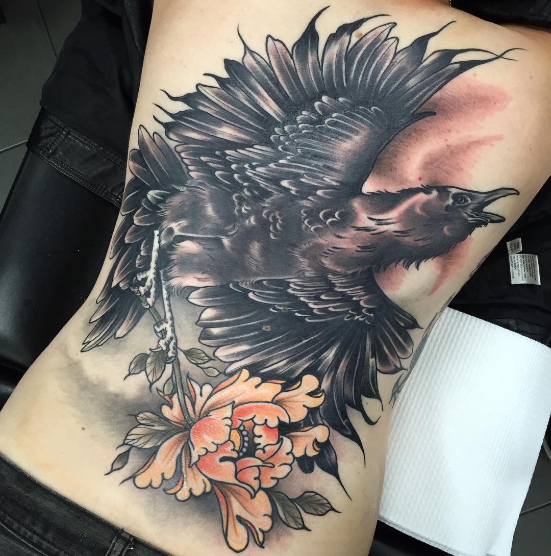huge crow tattoo on full back with a flower in its claws