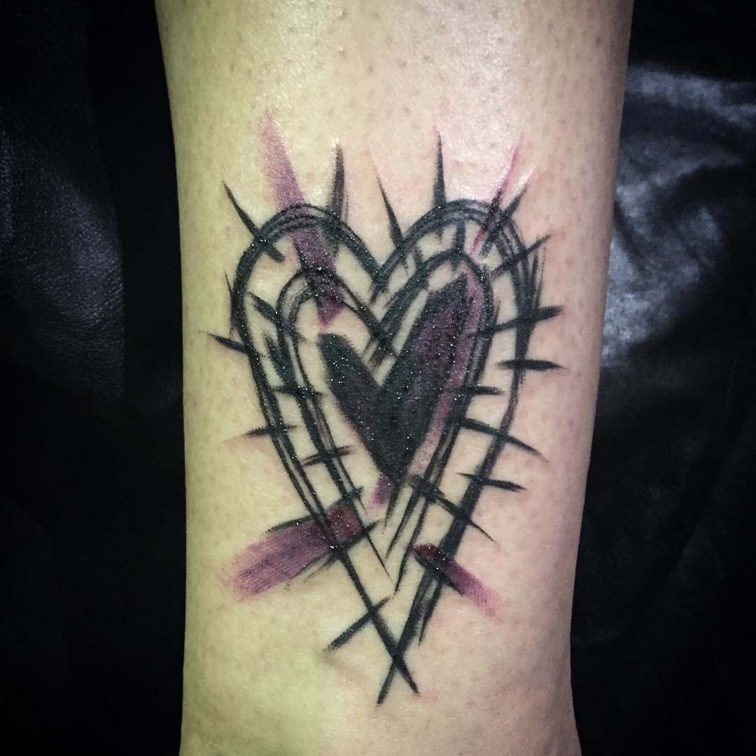 brush drawn heart tattoo on arm
