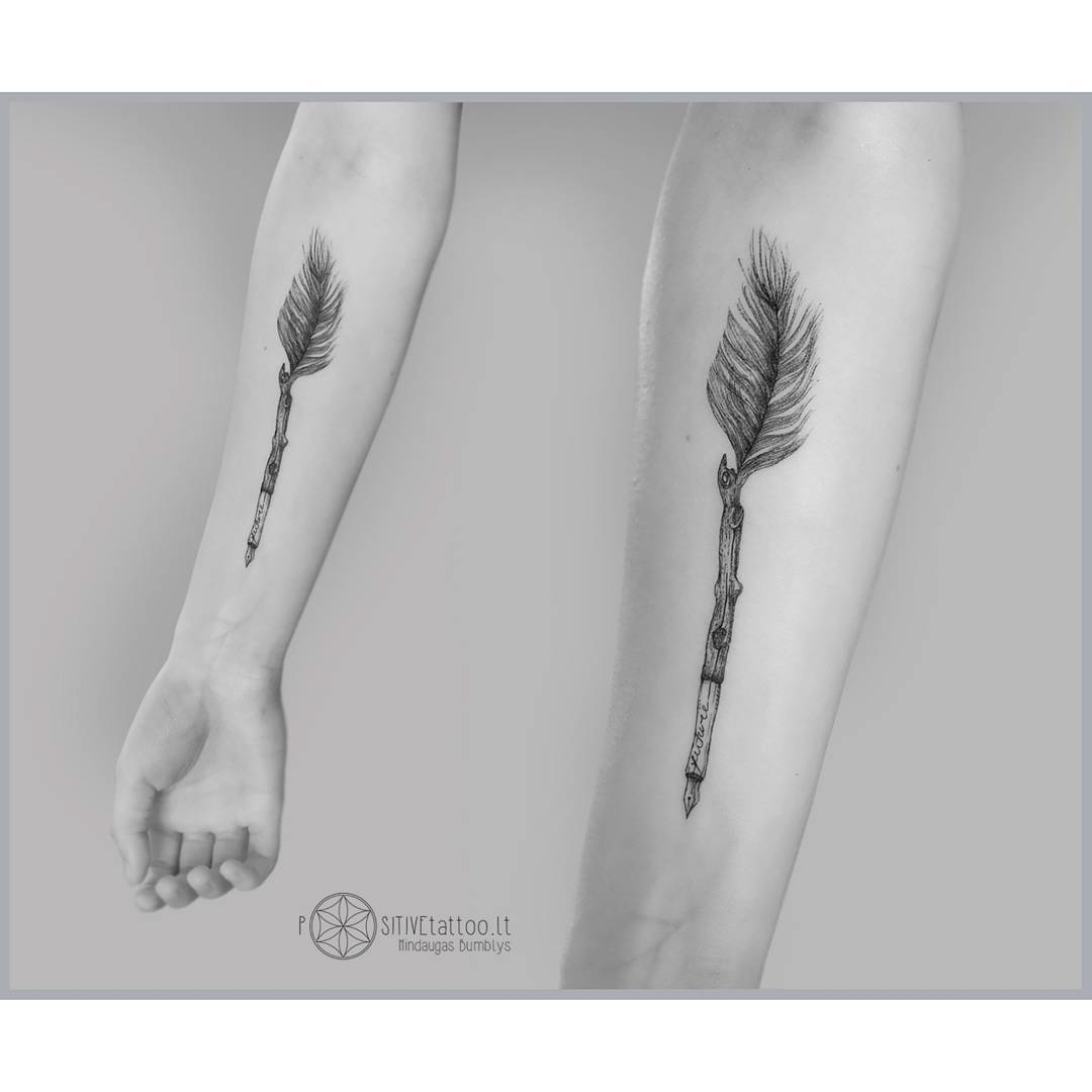 arm tattoo feather pen