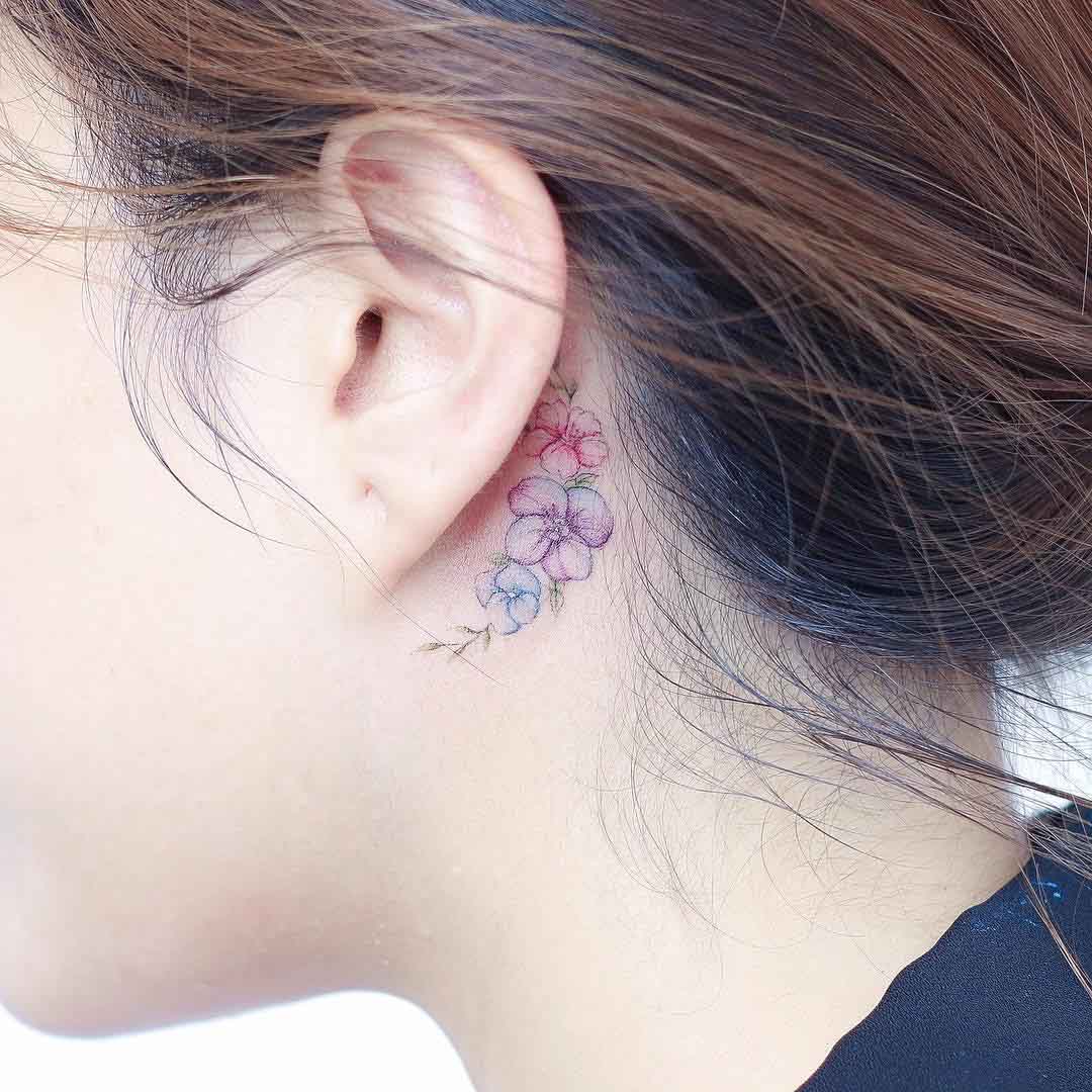 small flowers tattoo behind the ear